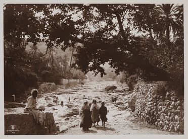  Lehnert & Landrock  (attivi a Tunisi, ) : Tunisia. Veduta di oasi con donne e bambini nei pressi di un ruscello.  - Auction Fotografie storiche - Libreria Antiquaria Gonnelli - Casa d'Aste - Gonnelli Casa d'Aste